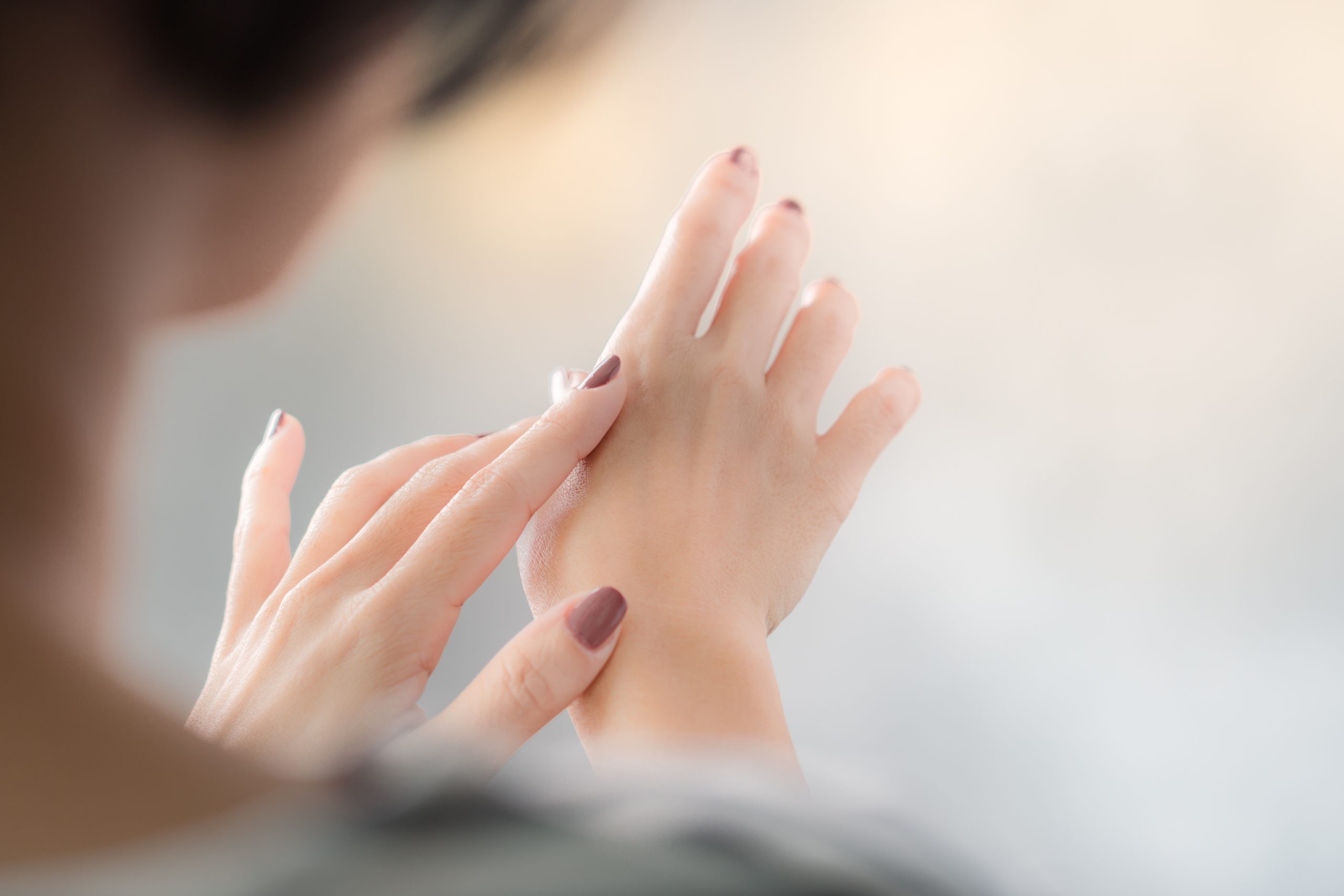 成分・こだわりのTOPページ。
女性が手を気にしている様子。