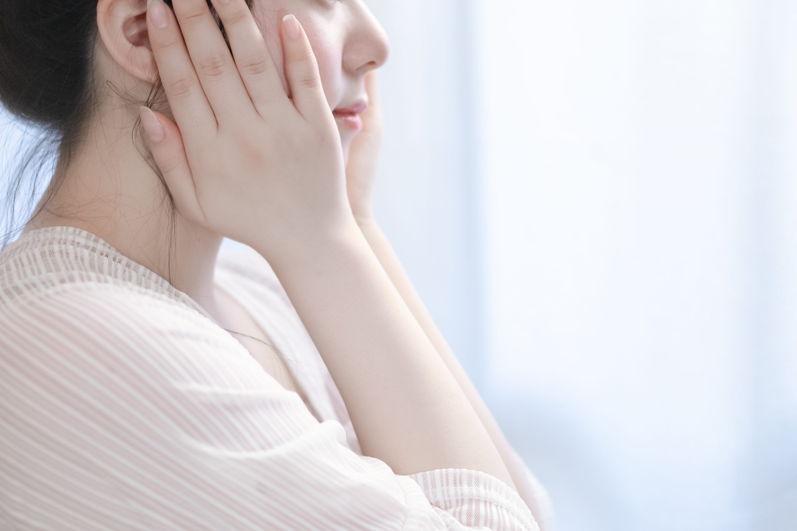 顔を両手で包み込んでいる女性の様子。